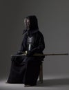 Portrait of man kendo fighter with bamboo sword in traditional uniform.