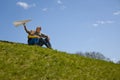 Portrait of man and kid boy sitting on top of hill and going to start paper airplane. Father and son together