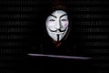 Portrait of man with laptop and vendetta mask isolated on black