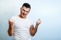 Portrait of a man on a light background, shows a gesture with his hands Rock n Roll. The concept of body language