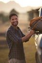 Portrait Of Man Loading Backpack Into Pick Up Truck For Road Trip To Cabin In Countryside Royalty Free Stock Photo