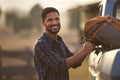 Portrait Of Man Loading Backpack Into Pick Up Truck For Road Trip To Cabin In Countryside Royalty Free Stock Photo