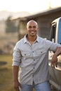 Portrait Of Man Loading Backpack Into Pick Up Truck For Road Trip To Cabin In Countryside Royalty Free Stock Photo