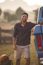 Portrait Of Man Loading Backpack Into Pick Up Truck For Road Trip To Cabin In Countryside Royalty Free Stock Photo