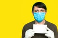 Portrait of an man in a medical mask and gloves. He is holding a clear piece of paper. Coronavirus with blankspace. Coronavirus