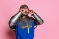 Portrait of man, medieval warrior or knight in armor suffering from pain, touching temples in headache isolated over Royalty Free Stock Photo