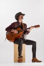 Portrait of man with moustaches in country style clothes playing guitar, singing isolated over white background Royalty Free Stock Photo