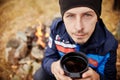 Portrait of a Man with a mug of hot tea in his hands fall in a forest fire. A picnic in forest Royalty Free Stock Photo