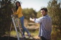 Portrait of man photographing girlfriend at olive farm