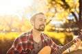 Portrait of man playing bass guitar in the park Royalty Free Stock Photo