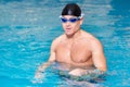 Portrait Of A Man Posing In Swimming Pool. Portrait Of A Young Wet Muscular Man Standing In Swimming Pool.