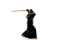 Portrait of man, professional kendo athlete in uniform posing, training with shinai sword against white studio Royalty Free Stock Photo