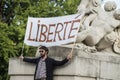 Portrait of man protesting in the street against the sanitary pass with banner and text in french : liberte, traduction in english