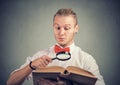 Portrait of a man reading an interesting book with magnifying glass Royalty Free Stock Photo