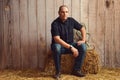 Portrait of man resting on hay bale in barn Royalty Free Stock Photo