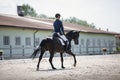 Man rider and black stallion horse galloping during equestrian dressage competition Royalty Free Stock Photo