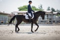 Man rider and black stallion horse trotting during equestrian dressage competition in summer Royalty Free Stock Photo