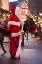 Portrait of man with santa claus costume and donkey at the christmas market
