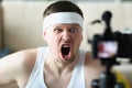 Man screaming on camera while performing exercise at home