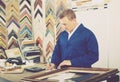 Portrait of man seller working with picture frames in atelier