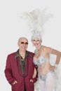 Portrait of man with senior showgirl against gray background