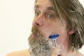 Portrait of man shaving. A variety of emotions. Cruelty and masculinity. Royalty Free Stock Photo