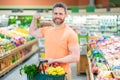 Portrait of man with shopping cart full of fresh vegetables in a food store. Supermarket shopping and grocery shop Royalty Free Stock Photo