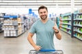 Portrait of man with shopping cart in a store. Supermarket shopping and grocery shop concept. Shopping. Guy buying Royalty Free Stock Photo