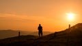 Man silhouette standing at the top of the mountain looking the landscape on sunset background Royalty Free Stock Photo
