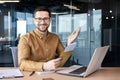 Portrait of a man sitting in the office and working on a laptop. Received and holds in his hands an envelope with a Royalty Free Stock Photo