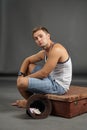 Portrait of a man sitting on a retro suitcase Royalty Free Stock Photo