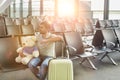 Portrait of man sitting with teddy bear and suit case while waiting for boarding in airport Royalty Free Stock Photo