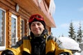 Portrait of man in ski clothes, with ski goggles on his head, sits at table outdoors. skier is resting after skiing, smiling, Royalty Free Stock Photo