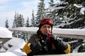 Portrait of man in ski clothes, with ski goggles on his head, sits at table outdoors. skier is resting after skiing, smiling, Royalty Free Stock Photo