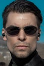 Portrait of a man with a smooth haircut and dark sunglasses looking like a secret agent or character from the movie The Matrix Royalty Free Stock Photo