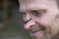 Portrait of a man with a snail on his nose. Funny moment. Funny face of a man looking at a snail crawling on his nose.