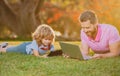 Portrait of man with son using digital tablet outside. New normal back to school. Elementary scholar pupil sitting with Royalty Free Stock Photo