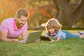 Portrait of man with son using digital tablet outside. New normal back to school. Elementary scholar pupil sitting with Royalty Free Stock Photo