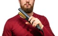 Portrait of man straightened his beard with a straightener, styling his beard on isolated white background Royalty Free Stock Photo