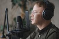 portrait of man in studio is recording podcast, audio content of interview on radio. Caucasian male Royalty Free Stock Photo