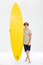 Portrait of a man in sunglasses and hat holding surfboard Royalty Free Stock Photo