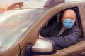 Portrait of a man with a surgical mask on his face in a car