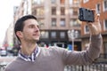 Portrait of man taking photo with retro camera in the street. Royalty Free Stock Photo