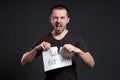 Portrait of a man tearing up an inscription on paper looking for a job