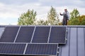 Portrait of man technician installing photovoltaic solar modules on roof of house. Royalty Free Stock Photo