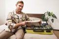 Portrait of man, tourist in hotel, packing or unpacking his suitcase, holding shirt, taking clothes out of luggage bag Royalty Free Stock Photo