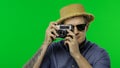 Portrait of man tourist photographer taking photos on retro camera. Chroma key