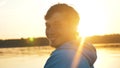 Portrait of man turns head around against background sunset on lake, outdoor activities alone Royalty Free Stock Photo