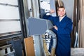 portrait of man in uniform working on large automatic saw machinery indoors