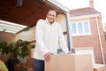 Portrait Of Man Unloading Furniture From Removal Truck Outside New Home On Moving Day Royalty Free Stock Photo